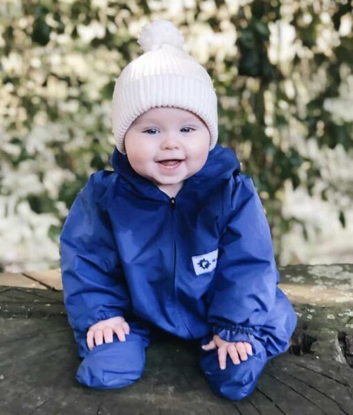 Baby wearing Mud Mates NZ-made waterproof overalls and shoe covers