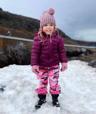 Young girl standing on snow, keeping dry, warm and comfortable with Mud Mates NZ-made waterproof Fleece Lined Pants