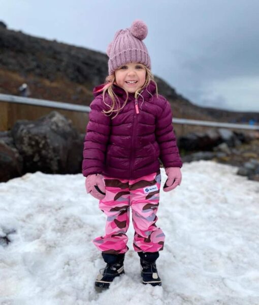 Young girl standing on snow, keeping dry, warm and comfortable with Mud Mates NZ-made waterproof Fleece Lined Pants