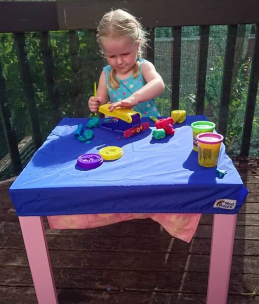 Young child playing playdough at a square table protected with a Mud Mates NZ-made fitted tablecloth