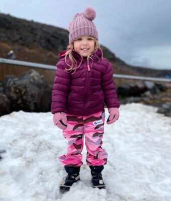 Young girl wearing Mud Mates pink camo waterproof fleece pants in the snow
