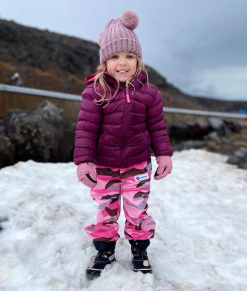 Young girl wearing Mud Mates pink camo waterproof fleece pants in the snow