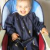 Baby in highchair messy with food wearing a Mud Mates NZ-made long sleeve bib