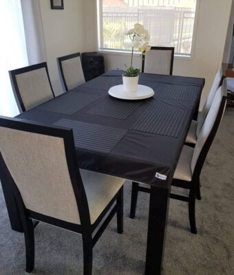 NZ-made custom black elasticated, fitted tablecloth protecting a dining room table