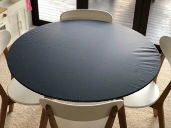 Black round elasticated fitted tablecloth on a table