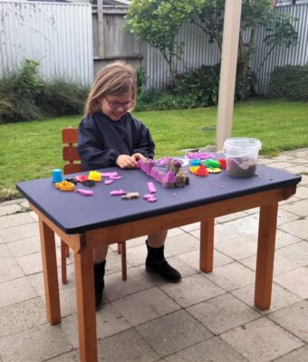 Child playing with playdough at a table covered with a Mud Mates NZ-made fitted tablecloth
