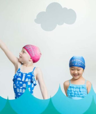 Girls wearing pink tiara and blue tiara lycra swim caps