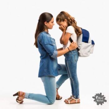 Upset girl with back to school anxiety being comforted by mum