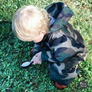 Toddler wearing Mud Mates NZ-made camo coveralls enjoying play outside