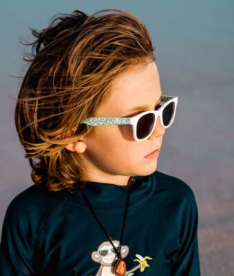 Fashionable young boy wearing Beachcomber Confetti Green kids sunglasses