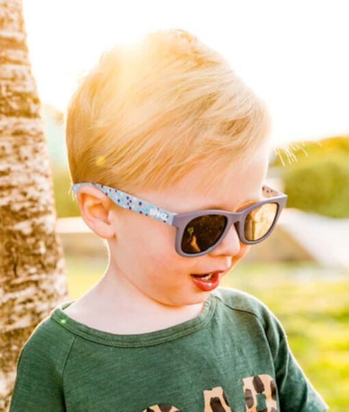 Toddler standing outside in the sun wearing Beachcomber Starry Nights kids sunglasses