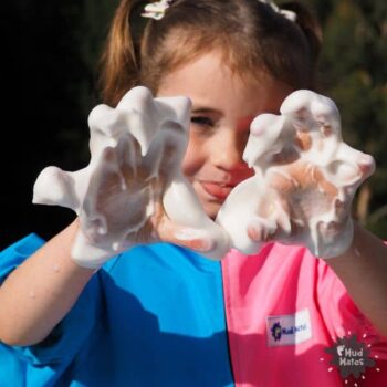 Young girls wearing Mud Mates waterproof Coveralls playing with taste-safe sensory foam (aquafaba)