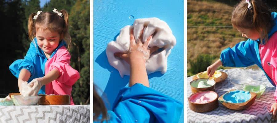Young girls wearing Mud Mates waterproof Coveralls playing with taste-safe sensory foam (aquafaba)