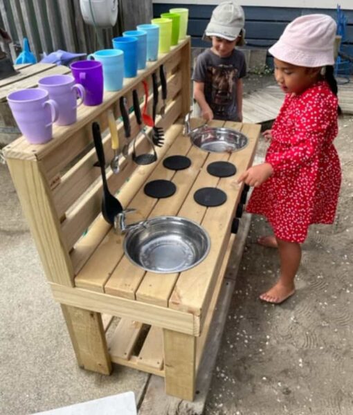 Children in ECE play at their wooden Mud Kitchen