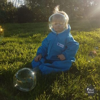 A young child having fun with giant bubbles