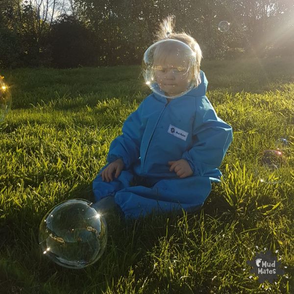 A young child having fun with giant bubbles