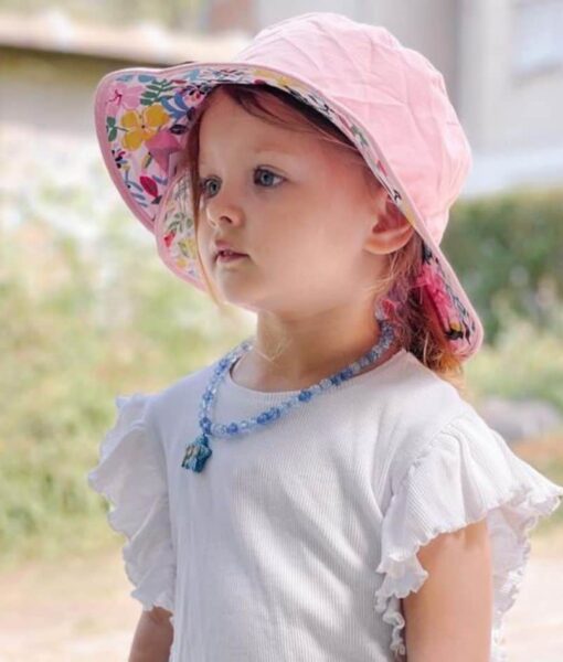 Young girl wearing a Botanical design reversible sun hat. Shop UPF 50+ reversible kids sun hats