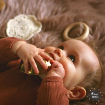 Baby lying down playing with loose parts | Navigating the Six Stages of Play with Your Child with Loose Parts