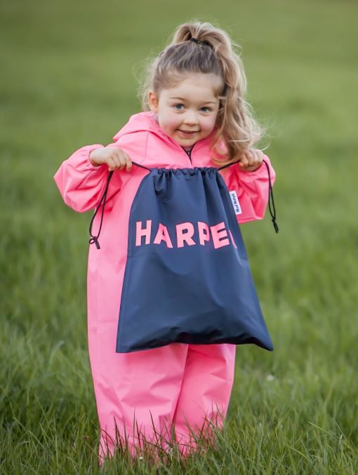 Mud Mates kids wet weather gear and more! Girl wearing Mud Mates waterproof overalls, holding a personalised Swim Bag