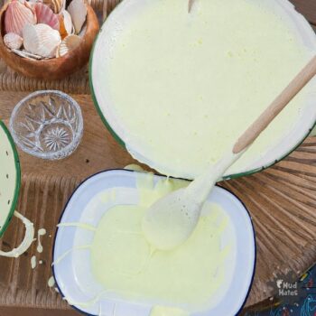 Whipped oobleck sensory play for kids - oobleck pouring slowly between trays outdoors