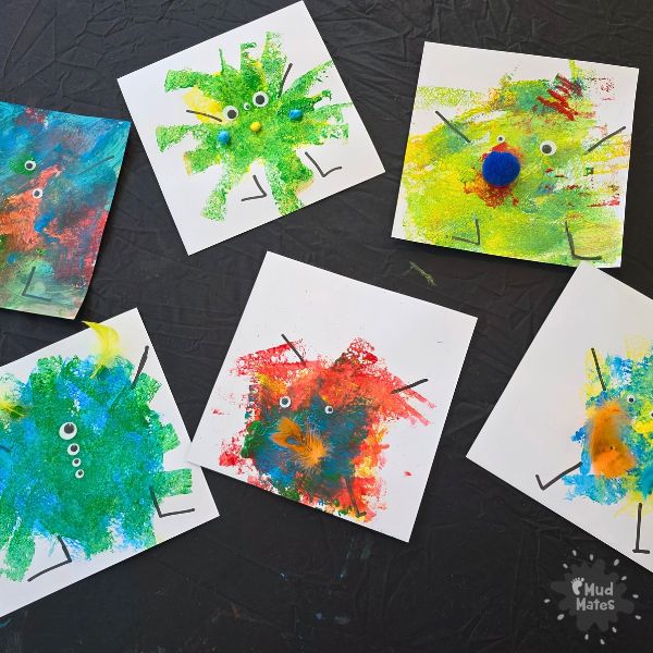 Easy halloween monster craft for toddlers - two sponge painted monsters on white cardstock with googly eyes on a dark background